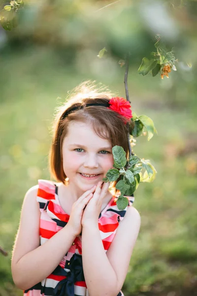 Gülümseyen ve çiçek açan şubesine poz sevimli kız portresi