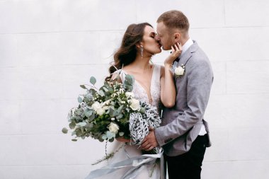 Closeup of lovely newlyweds kissing in garden clipart