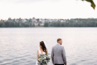 Nehir arka plan üzerinde duran üzgün yeni evliler