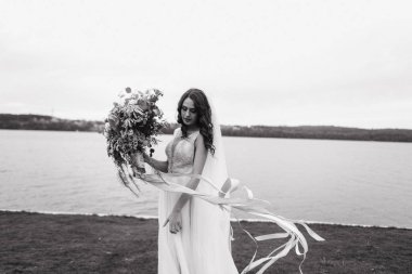 Gelin düğün buket tarafından nehir kıyısında yürüyüş ile