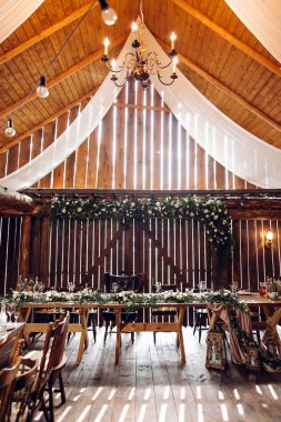 Festive dining room in rustic style decorated  with white flowers