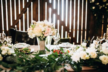 Festive table decorated with white roses and various flowers