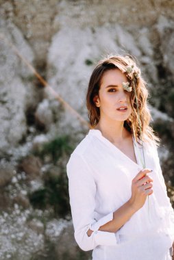 Woman with wavy hair playing with herbs posing on field