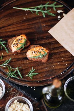 Çavdar ekmekli tost ve tahtadan yapılmış roka ile somon.