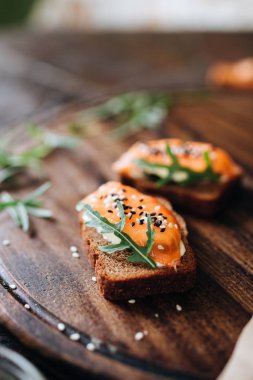 Çavdar ekmekli tost ve tahtadan yapılmış roka ile somon.