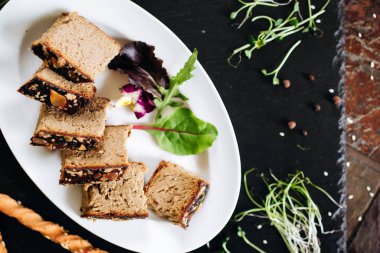 Dilimlenmiş rulo köfte ve yaprak ile servis edilen tohumlar.