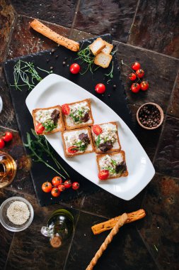 Toasts with eggs and vegetables served on oval plate