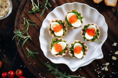 Ispanak, bıldırcın yumurtası ve somon havyarlı fırın sepetleri.