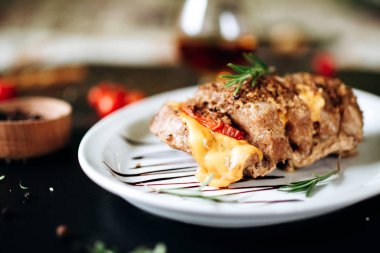 Erimiş peynirli ve otlu domuz rostosu.