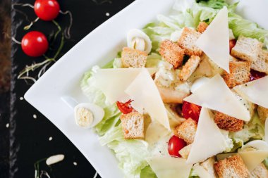 Beyaz tabakta servis edilen İtalyan Sezar salatası.