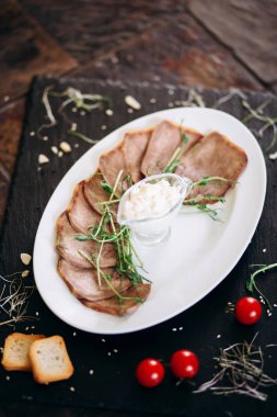 Sos ve otlarla dilimlenmiş sığır dili.