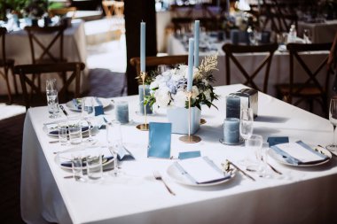 Güzel bir düğün masası süsü ve mavi renkli mumlar.