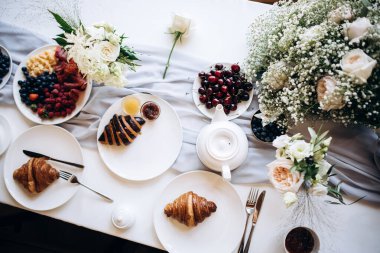 Doğada meyve, çay ve kruvasanla düğün kahvaltısı. Düğün buketi
