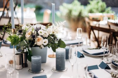 Güzel bir düğün masası süsü ve mavi renkli mumlar.