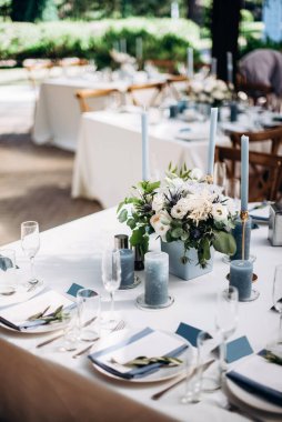 Güzel bir düğün masası süsü ve mavi renkli mumlar.