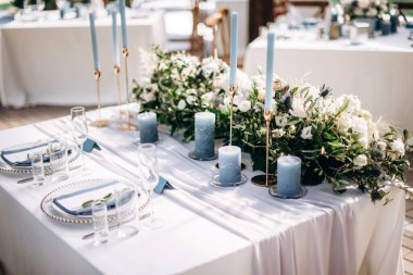 Güzel bir düğün masası süsü ve mavi renkli mumlar.