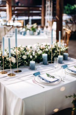 Güzel bir düğün masası süsü ve mavi renkli mumlar.