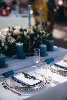 Güzel bir düğün masası süsü ve mavi renkli mumlar.