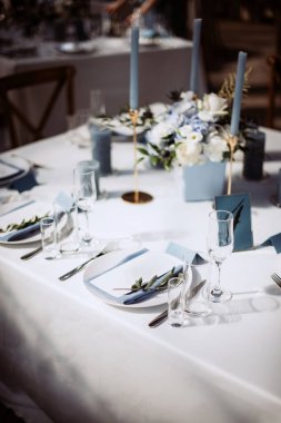 Güzel bir düğün masası süsü ve mavi renkli mumlar.