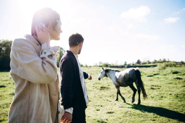 Erkek ve kadın el ele tutuşarak sahada yürüyor