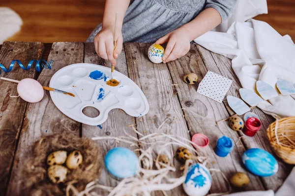 复活节快乐 可爱的小女孩把鸡蛋涂成蓝色和黄色 桌上乱糟糟的 — 图库照片