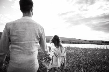 Arka plan beni takip edin. Sahada birbirine aşık mutlu bir çift sarılıyor, öpüşüyor ve gülümsüyor..