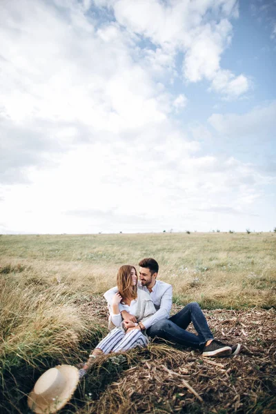 Krásný Pár Objímající Líbající Usmívající Proti Obloze Sedící Trávě Mezera — Stock fotografie