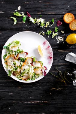 Beyaz tabakta taze kesilmiş sebzeli balık. Düz Yat