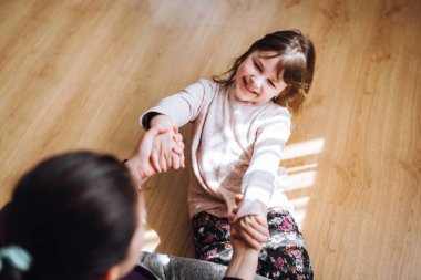 Karantina sırasında annesiyle evde eğlenen bir kız. Anne ve kızı sarılıyor.