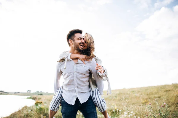楽しさ 抱きしめ フィールドの空の背景に笑顔を持つ美しい愛情のあるカップル 男と女の子のヒップスター旅行 — ストック写真