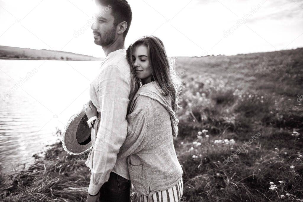 Close up portrait guy and girl hipster travel. Beautiful loving couple having fun, cuddling, smiling on sky background in field. 