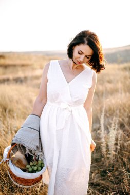 Şapkalı güzel kız dağlarda yürüyor ve günbatımını seyrediyor. Akşam dağlarında seyahat etmek. Metin için boşluk 