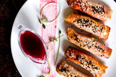 Susamlı domuz eti, sefalet ve kızılcık sosu.