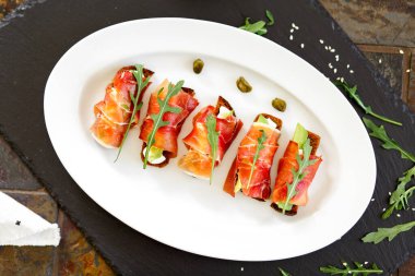 Jambonlu aperatif. Jambona sarılı avokado ve peynirli ekmek.