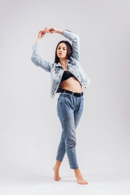 Kotlu ve iç çamaşırlı güzel, seksi esmer kız beyaz arka planda poz veriyor.