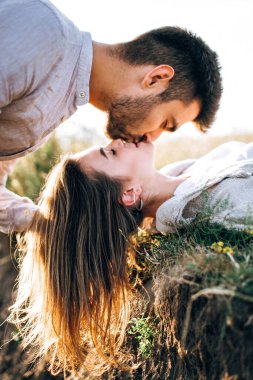 Çimlerin üzerinde yatan güzel bir çiftin portresi. Nazikçe dokun 