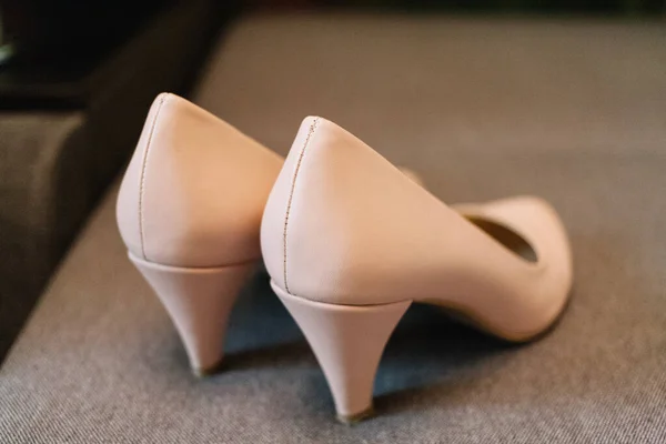 beige bridesmaid shoes on the bed of wedding day