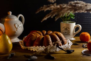 İtalyan usulü pandoro kahveli, beyaz, eski püskü çaydanlık ve siyah karatahta kaplı meyveler..