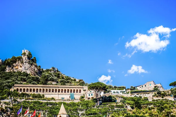 Città di Amalfi vista panoramica paesaggio urbano sulla torre dello ziro, scogliera rocciosa di montagna e cielo blu . Foto Stock Royalty Free