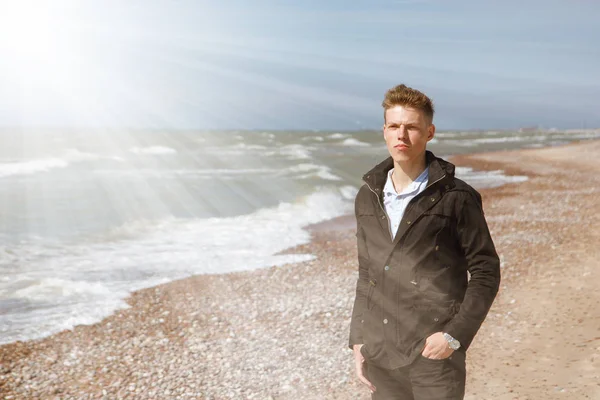 Jeune homme marchant le long du littoral — Photo