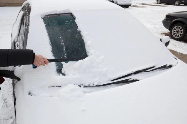 Cleaning snow from car — Stock Photo, Image