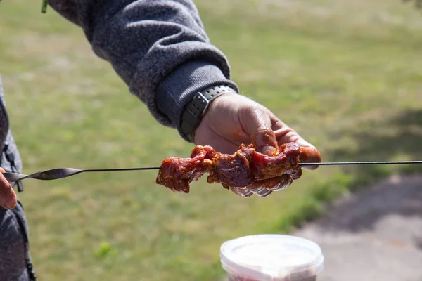 Hands of a man putting meat on skewer for barbecue. — Stock Photo, Image