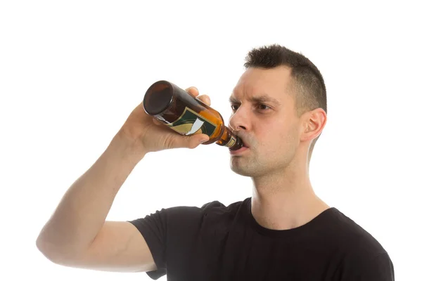 Alkalmi fiatalember iszik egy üveg sört. — Stock Fotó