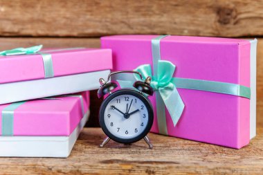 Ahşap zemin üzerinde çalar saat ve hediye kutusu