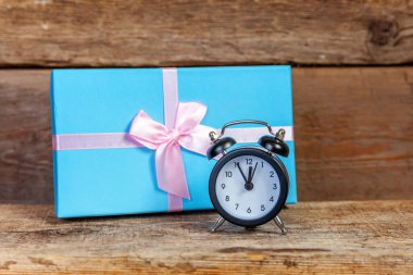 Ahşap zemin üzerinde çalar saat ve hediye kutusu