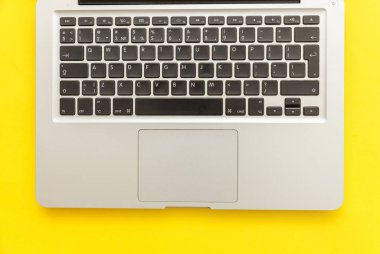 Sarı masa arka planda yalıtılmış klavye dizüstü bilgisayar. Modern bilgi teknolojisi ve yazılım gelişmeleri