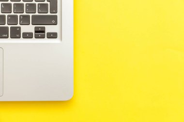 Sarı masa arka planda yalıtılmış klavye dizüstü bilgisayar. Modern bilgi teknolojisi ve yazılım gelişmeleri