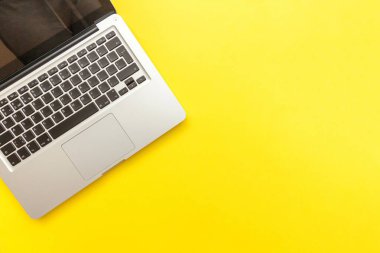Sarı masa arka planda yalıtılmış klavye dizüstü bilgisayar. Modern bilgi teknolojisi ve yazılım gelişmeleri