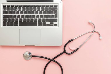 Pembe arka plan üzerinde izole Stetoskop klavye dizüstü bilgisayar. Modern tıbbi Bilgi teknolojisi ve sofware gelişmeler kavramı. Bilgisayar ve gadget tanılama ve onarım