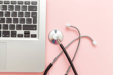 Pembe arka plan üzerinde izole Stetoskop klavye dizüstü bilgisayar. Modern tıbbi Bilgi teknolojisi ve sofware gelişmeler kavramı. Bilgisayar ve gadget tanılama ve onarım